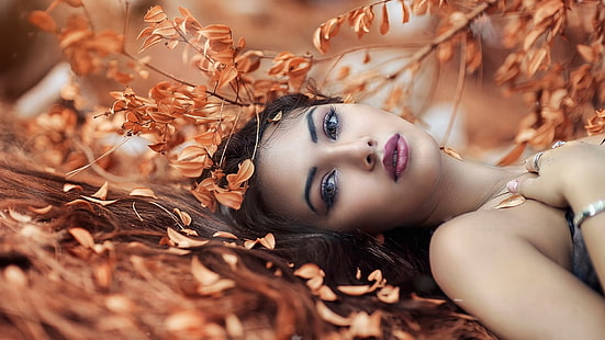 woman's face, untitled, women, model, brunette, long hair, looking at viewer, women outdoors, face, portrait, bare shoulders, nature, makeup, lying on back, leaves, fall, depth of field, HD wallpaper HD wallpaper