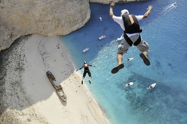 skydiving, men, sports, jumping, bird's eye view, sand, helmet, beach, sea, rock, boat, sunlight, Greece, parachutes, HD wallpaper