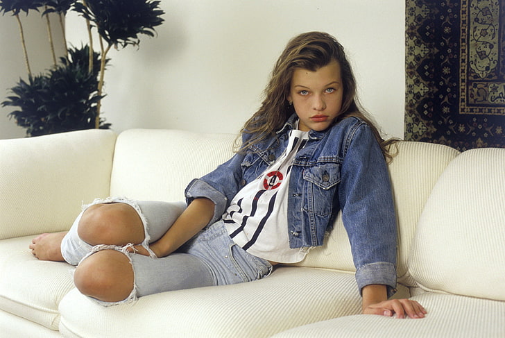 Milla Jovovich, look, girl, flowers, sofa, wall, movie, the film, carpet, model, jeans, earrings, Hollywood, actress, Milla Jovovich, t-shirt, mole, art, long hair, eyes, close, young, beauty, brunette, babe, posing, sitting, celebrity, knees, jacket, vest, Mila, young girl, Known, personality, mortality, Jovovich, the jacket, feed, hope, HD wallpaper