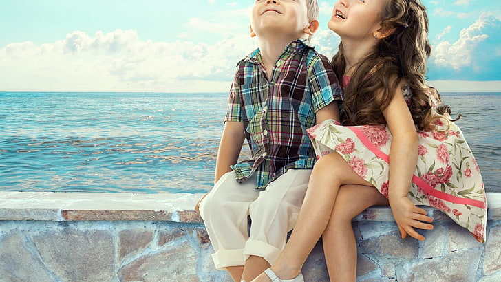 صبي وفتاة يجلسان على مقعد أسمنتي بني بجانب البحر خلال النهار ، أطفال ، فتاة صغيرة ، ولد صغير، خلفية HD