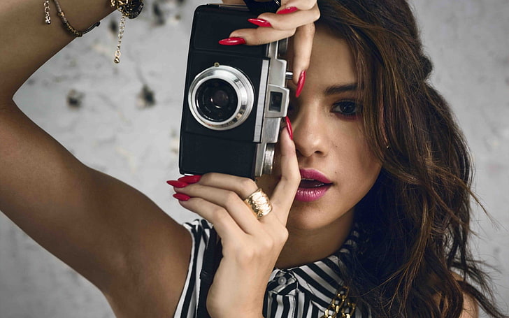 woman holding black and silver SLR camera, Selena Gomez, women, brunette, face, camera, painted nails, red nails, open mouth, long hair, long nails, HD wallpaper