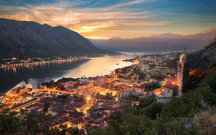 lighted city buildings, nature, landscape, cityscape, Kotor (town), Montenegro, mountains, sunset, mist, architecture, sky, clouds, evening, lake, sun rays, church, HD wallpaper