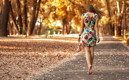 فستان نسائي بلا أكمام أحمر ، أبيض ، وأخضر ، امرأة ترتدي فستان زهري يمشي في طريق الرصيف الرمادي بين الأشجار البنية ، النساء في الهواء الطلق ، المتنزه ، حافي القدمين ، اللباس ، الخريف ، النساء ، في الهواء الطلق ، النموذج، خلفية HD HD wallpaper