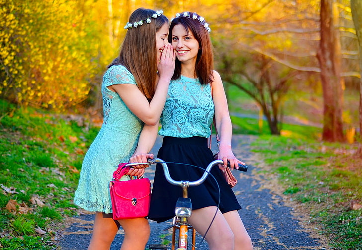 woman wearing teal cap sleeve whispering woman on riding bicycle, women, model, wreaths, friendship, see-through blouse, brunette, women outdoors, women with bicycles, HD wallpaper