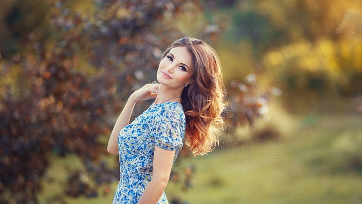 women's blue and white floral top, woman wearing blue and white floral crew-neck dress, women, model, brunette, long hair, women outdoors, nature, looking at viewer, blue eyes, smiling, trees, depth of field, dress, wavy hair, bokeh, HD wallpaper