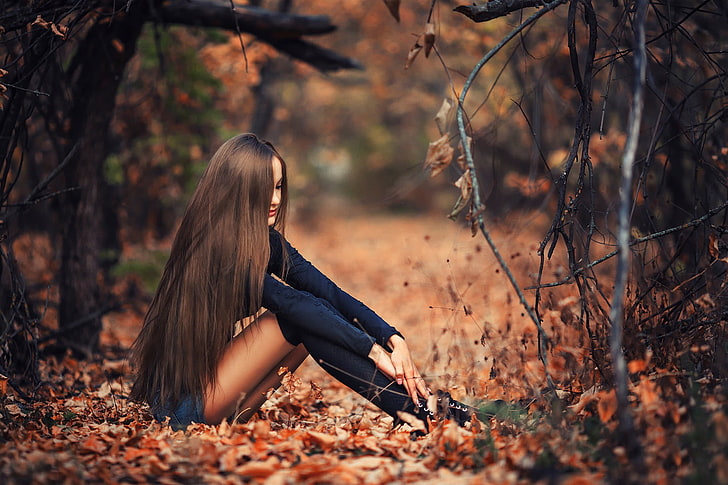 women's blue long-sleeved top, woman sitting on brown dried leaves taken during daytime, women, brunette, long hair, women outdoors, fall, leaves, sitting, branch, trees, model, nature, hair in face, knee-highs, jean shorts, black clothing, skinny, straight hair, HD wallpaper