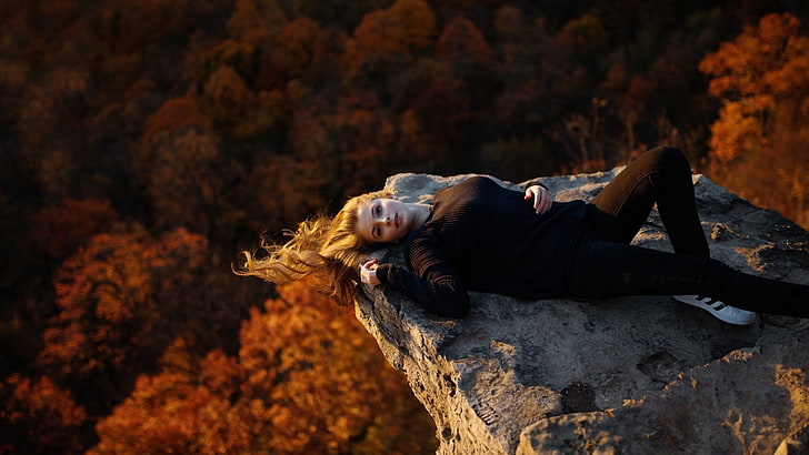 women's black long-sleeved shirt, woman in black shirt laying on rocky mountain, women, model, blonde, long hair, women outdoors, nature, trees, lying on back, looking at viewer, black clothing, open mouth, rock, forest, windy, sneakers, Adidas, skinny jeans, fall, blue eyes, HD wallpaper