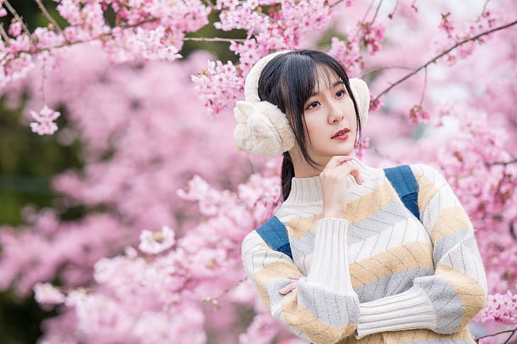 Asian, model, women, depth of field, long hair, brunette, cherry blossom, pullover, backpacks, ponytail, ear muffs, looking into the distance, trees, HD wallpaper