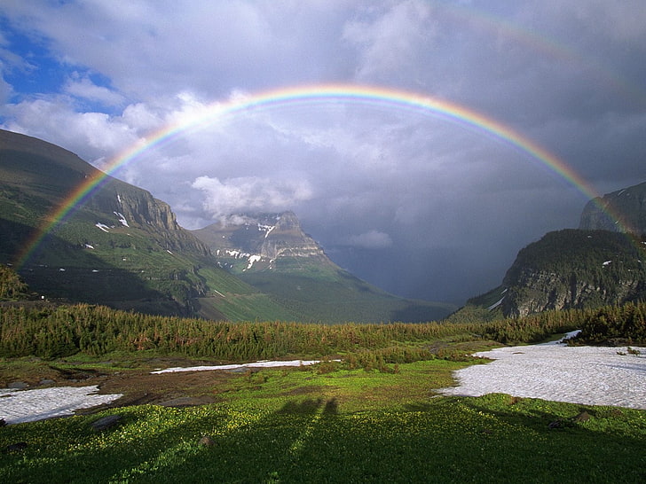 nature photography of rainbow over grass field near mountains, mountains, rainbow, snow, greens, clouds, HD wallpaper