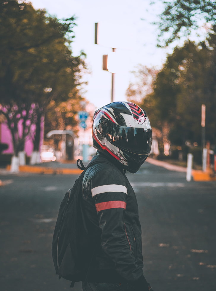 black, white, and red full-face helmet, motorcyclist, helmet, jacket, backpack, blur, HD wallpaper