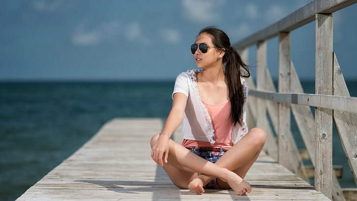 black haired woman in sunglasses sitting on dock beside body of water, women, feet, sunglasses, pier, HD wallpaper