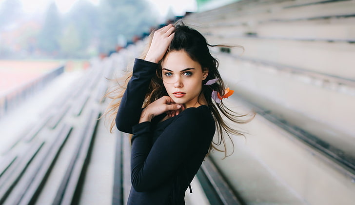 women's black long-sleeved top, woman wearing black long-sleeved top, women, model, brunette, long hair, women outdoors, looking at viewer, black clothing, blue eyes, open mouth, hands on head, stadium, HD wallpaper