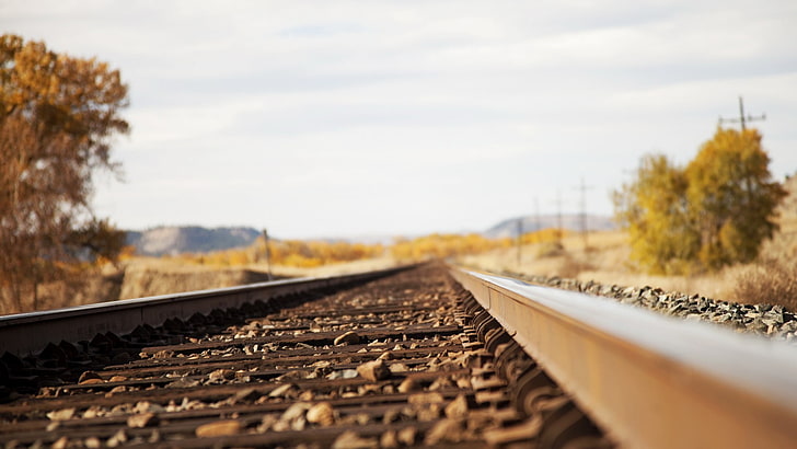нискоъгълен изглед селективен фокус снимка на кафяви метални влакови коловози, железопътна линия, дълбочина на рязкост, камъни, изглед на червеево око, HD тапет
