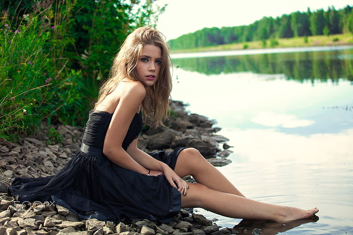 women's black strapless dress, women, model, blonde, green eyes, dress, riverside, river, women outdoors, barefoot, sitting, Ksenia Kokoreva, HD wallpaper