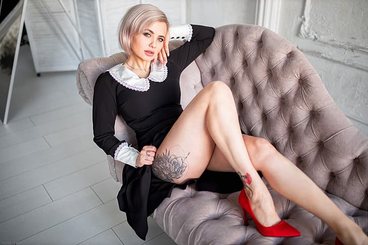 Alexey Yuriev, modelo, mujer, rubia, ojos azules, piernas, tatuaje, vestido, vestido negro, tacones altos, zapatos rojos, sofá, labios entreabiertos, tocar la cara, sentado, mirando al espectador, retrato, Fondo de pantalla HD