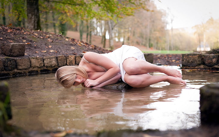 women, model, blonde, long hair, white dress, barefoot, women outdoors, water, trees, lying on side, cleavage, water drops, wet, wet body, minidress, nature, fall, leaves, rock, legs together, bare shoulders, fetal position, HD wallpaper