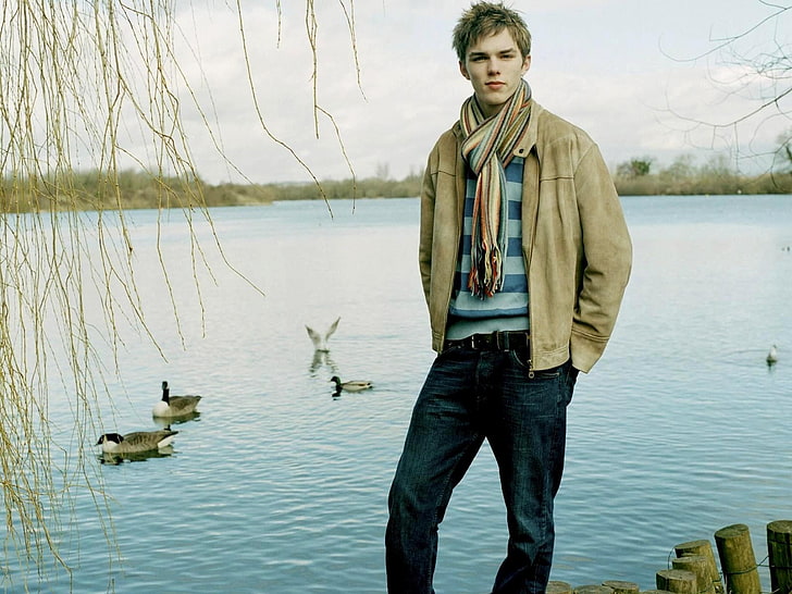 мужская коричневая куртка на молнии, Николас Холт, актер, парень, пруд, река, деревья, HD обои