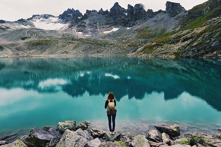 femme debout sur un rocher près d'un plan d'eau, photographie, nature, paysage, lac, randonnée pédestre, turquoise, eau, montagnes, femmes, ciel couvert, lumière du jour, Fond d'écran HD