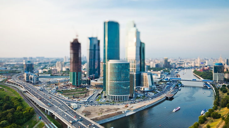 gray and clear glass high-rise building, aerial photography of high-rise buildings near body of water, city, tilt shift, river, cityscape, traffic, vehicle, HD wallpaper