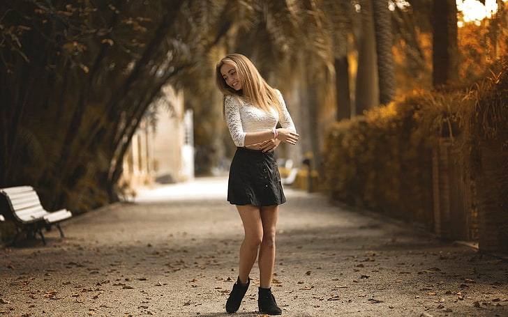 women's white lace long-sleeved top, woman wearing white lace long-sleeved top and black mini skirt, women, model, blonde, long hair, women outdoors, nature, smiling, white tops, skirt, street, path, trees, leaves, fall, bench, depth of field, park, black skirts, HD wallpaper