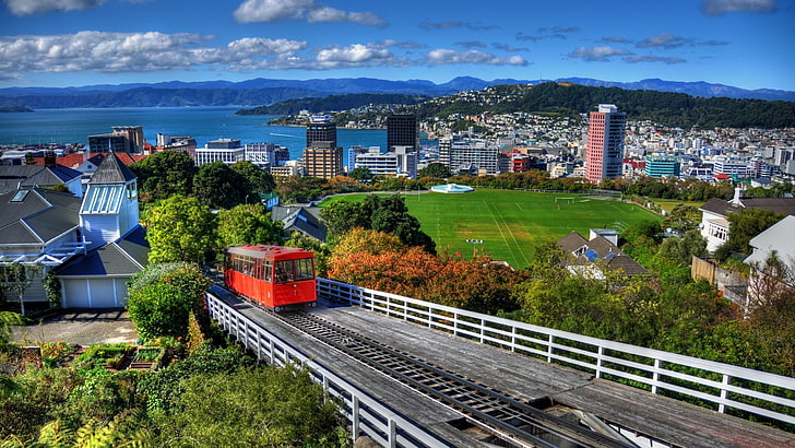 train on rail, architecture, building, Wellington, New Zealand, city, cityscape, train, hills, Soccer Field, clouds, house, trees, sea, railway, grass, HD wallpaper