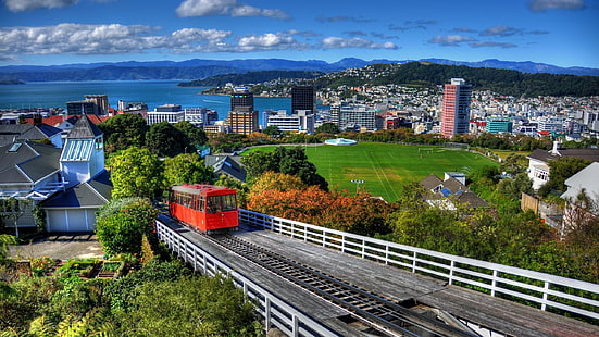 поезд на железной дороге, архитектура, здание, Веллингтон, Новая Зеландия, город, городской пейзаж, поезд, холмы, футбольное поле, облака, дом, деревья, море, железная дорога, трава, HD обои HD wallpaper