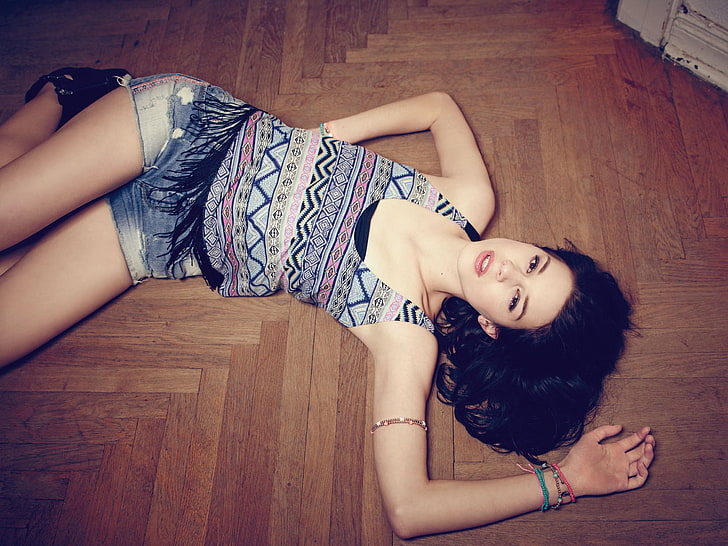 woman lying on brown wood parquet flooring, women, model, brunette, long hair, lying down, on the floor, wooden surface, open mouth, looking at viewer, jean shorts, tank top, legs, HD wallpaper