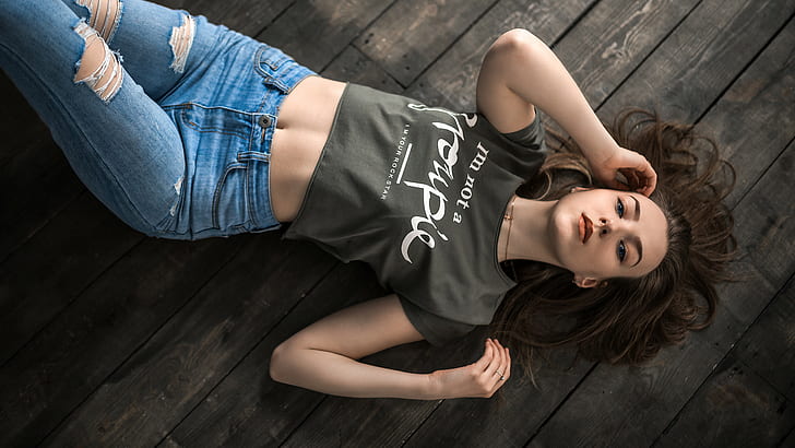 lying on front, top view, T-shirt, belly, wooden surface, torn jeans, women, ripped clothes, blue eyes, necklace, HD wallpaper