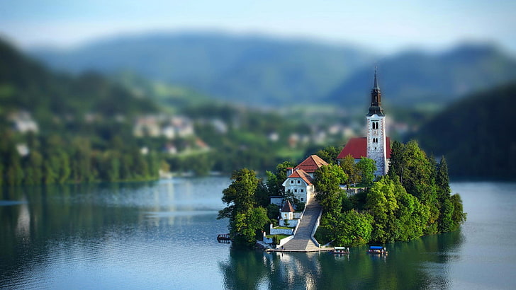 red and white concrete storey house, islet with house, tower, and slide, blurred, church, tilt shift, Lake Bled, island, HD wallpaper