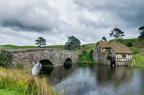 photography of brown house near body of water surrounded by trees under gray sky, Hobbiton, mill, double, arched bridge, photography, brown house, body of water, trees, LOTR, Hobbit, New Zealand, Nikon  D5100, HDR, Tokina, 16mm, nature, cultures, river, architecture, history, water, HD wallpaper HD wallpaper
