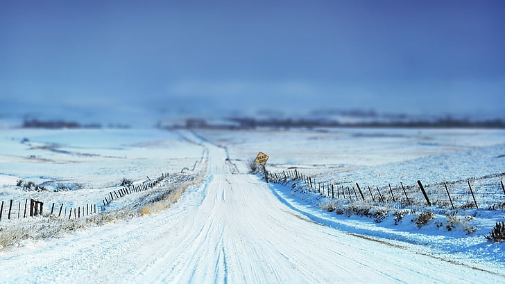 dirt road covered by snow, snow, tilt shift, winter, road, signs, fence, landscape, cyan, white, sky, field, nature, shrubs, HD wallpaper