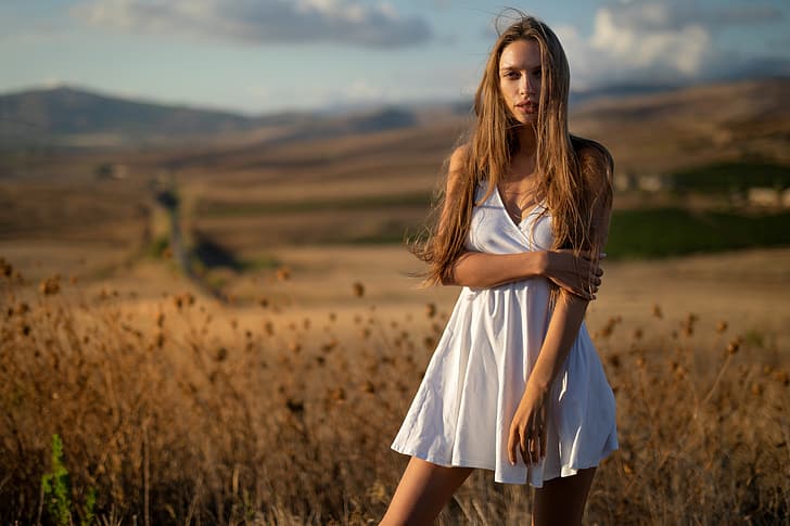 Alina, field, nature, clouds, bokeh, blue sky, outside, sexy woman, countryside, posing, white dress, beautiful face, outdoors, sexy brunette, blurred background, looking at camera, long brown hair, elegant dress, sensual beauty, hot pretty girl, tanned girl, standing alone, gorgeous woman, stunning beauty, bewitching beauty, awesome beauty, magnificent beauty, terrific girl, gold plants, HD wallpaper