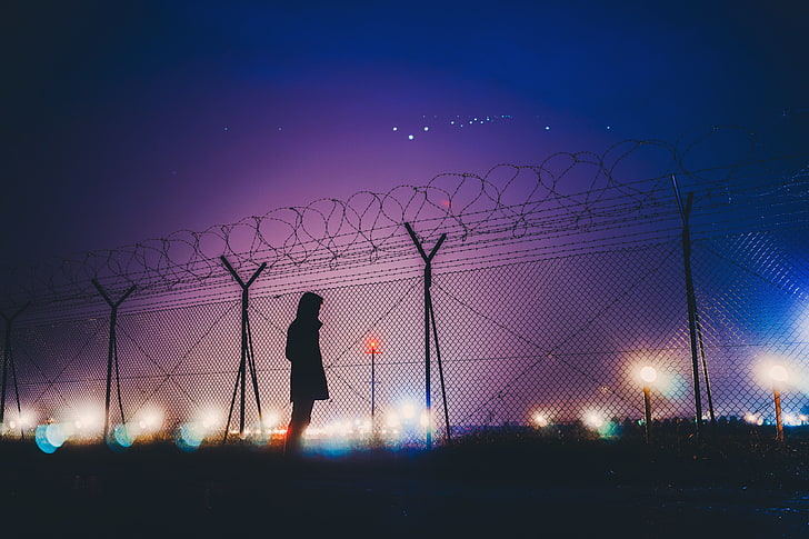 sylwetka osoby stojącej obok szarego metalowego ogrodzenia, mężczyzna, sylwetka, noc, drut kolczasty, Tapety HD