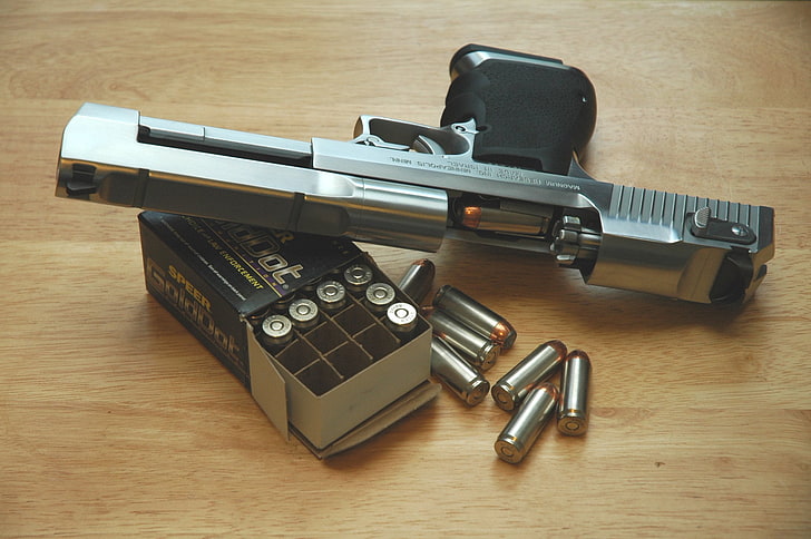 مسدس نصف أوتوماتيكي من الفولاذ الرمادي مع صندوق ، بندقية ، خراطيش ، نسر الصحراء، خلفية HD
