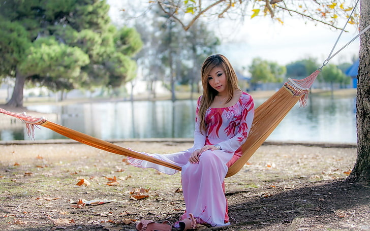 women's purple and red long-sleeved maxi dress, woman in white and red floral long-sleeved dress sitting on brown hammock during daytime, women, model, blonde, long hair, women outdoors, Asian, sitting, see-through clothing, dress, trees, lake, leaves, fall, park, high heels, alone, hammocks, sad, oriental, necklace, HD wallpaper