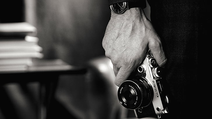 Graustufenfoto eines Mannes mit Kamera, Olympus PEN-F, spiegellose Kamera, Test, Körper, 4k-Video, Objektiv, Unboxing, HD-Hintergrundbild