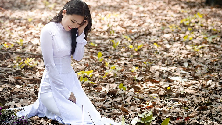 women's white long-sleeved dress, woman wearing white long-sleeved dress kneeling on the ground, Asian, smiling, leaves, white dress, áo dài, women outdoors, HD wallpaper