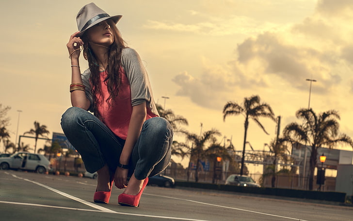 여자의 빨간색과 회색 라글란 셔츠와 검은 청바지, 펌프, 하이힐, 모자, 여자, 모델, 쪼그리고 앉는, 도시의, 빨간 발 뒤꿈치, 팔찌, HD 배경 화면