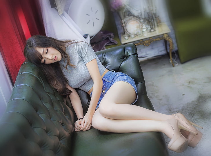 woman wearing gray crop top and blue denim short shorts sitting on black leather sofa, Asian, women, brunette, legs, high heels, couch, HD wallpaper