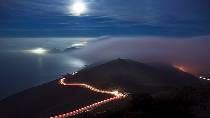 Zeitrafferfotografie von Fahrzeugscheinwerfern rund um Berg, Küste, Natur, Wolken, Straße, Langzeitbelichtung, Himmel, Nacht, Landschaft, HD-Hintergrundbild