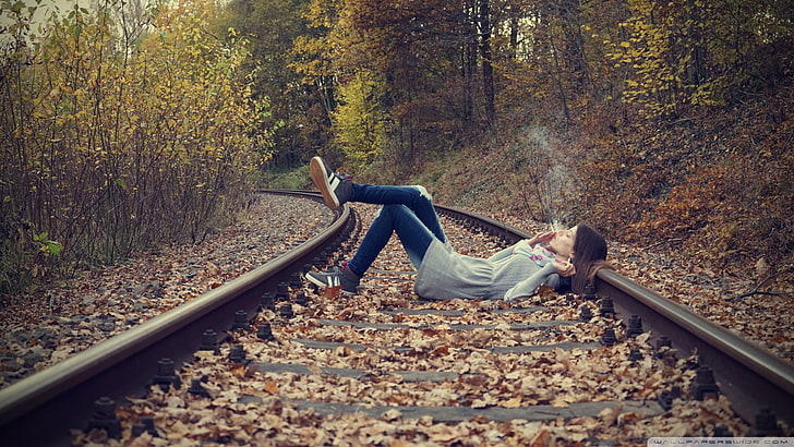 femme en jeans allongée sur le train, femmes, femmes à l'extérieur, forêt, cigarettes, tabagisme, chemin de fer, feuilles, yeux fermés, photographie, Chill Out, couchée, jeans, automne, Fond d'écran HD