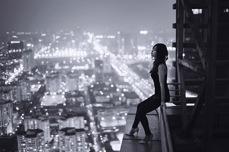 Graustufenfoto der Frau sitzend auf Pfosten auf Gebäude, Graustufenfoto der Frau sitzend auf Gebäude, Frauen, Monochrom, Stadtbild, Gebäude, Asiat, Dachspitzen, Modell, Lichter, HD-Hintergrundbild