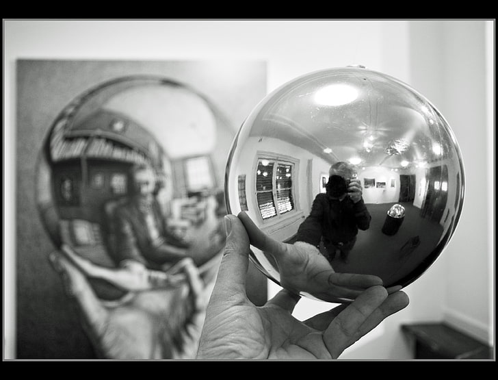 человек держит мяч рядом с картиной в градациях серого фото, монохромный, М. С. Эшер, стекло, сфера, мужчины, самостоятельная съемка, камера, руки, отражение, HD обои