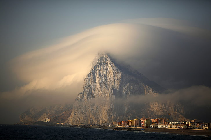 серая скалистая гора над деревней, природа, пейзаж, здание, дом, море, Гибралтар, Великобритания, облака, горы, город, туман, побережье, пляж, HD обои
