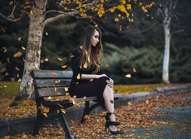 жена седи на пейка до пътя, жена в черна рокля седи, жени на открито, падане, пейка, жени, модел, листа, седнал, дълга коса, крака, дървета, HD тапет