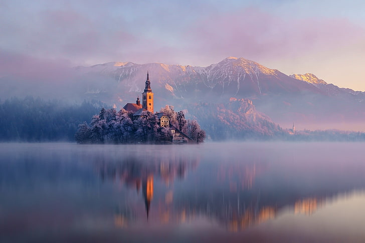 biała ośnieżona góra, brązowy dom w pobliżu zbiornika wodnego, natura, krajobraz, architektura, kościół, drzewa, góry, zima, śnieg, mgła, wyspa, jezioro, woda, odbicie, zachód słońca, Słowenia, jezioro Bled, poranek, mróz, Tapety HD