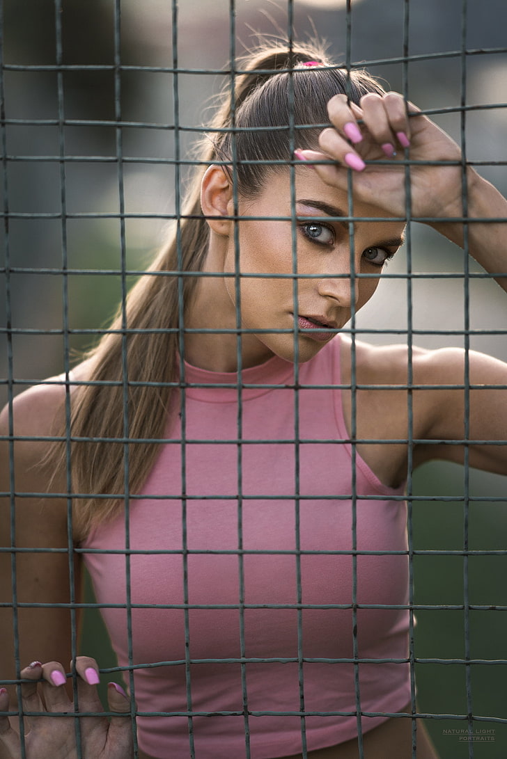women, model, brunette, looking at viewer, 500px, depth of field, fence, ponytail, blue eyes, pink tops, pink nails, HD wallpaper