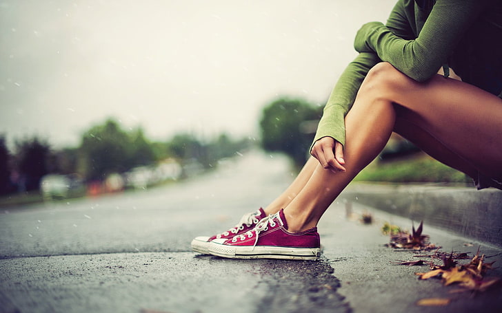 pair of red Converse All-Star low-tops, person wearing pair of maroon-and-white low-top sneakers, women, Converse, legs, rain, alone, pavements, women outdoors, sitting, green, green clothing, wet street, asphalt, HD wallpaper