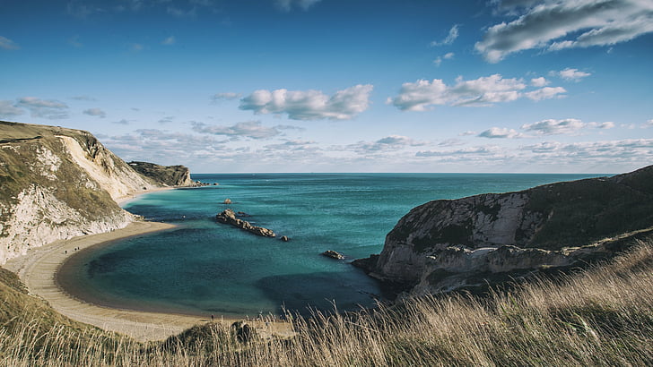 kust nära stenigt berg under blå och vit himmel, Jurassic Coast, 5k, 4k tapeter, Dorset, England, stenar, himmel, moln, HD tapet