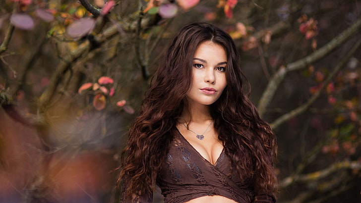 women's brown surplice neckline top, photo of woman in brown plunging neckline long-sleeved top, women, model, brunette, long hair, women outdoors, nature, trees, fall, leaves, wavy hair, looking at viewer, open mouth, face, portrait, brown eyes, bokeh, depth of field, cleavage, HD wallpaper